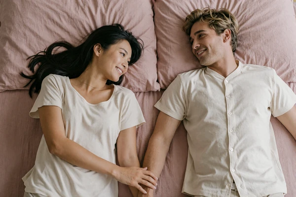Affectionate fully-clothed couple holding hands, representing comfort-focused small penis intimacy